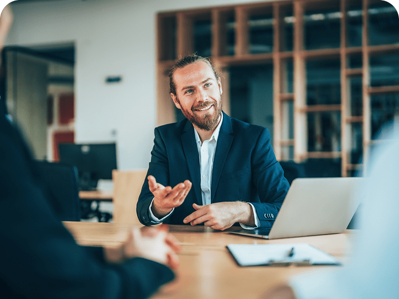 Man in meeting, gesturing while speaking.