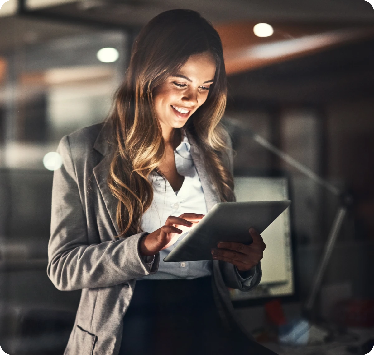 Woman smiling while using a digital tablet.